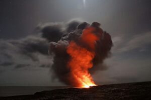 An image of a volcano erupting at night as an example of covered damages under specific landlord policies
