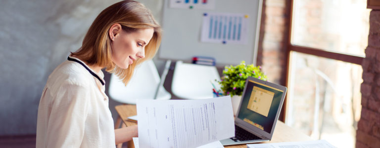 woman reading rental application form at desk