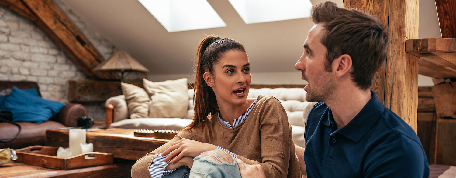 couple looking at each other arguing in a house