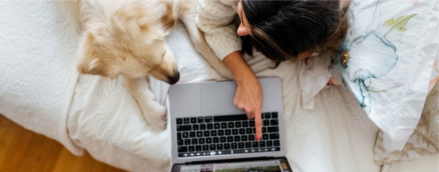 woman laying on bed with dog