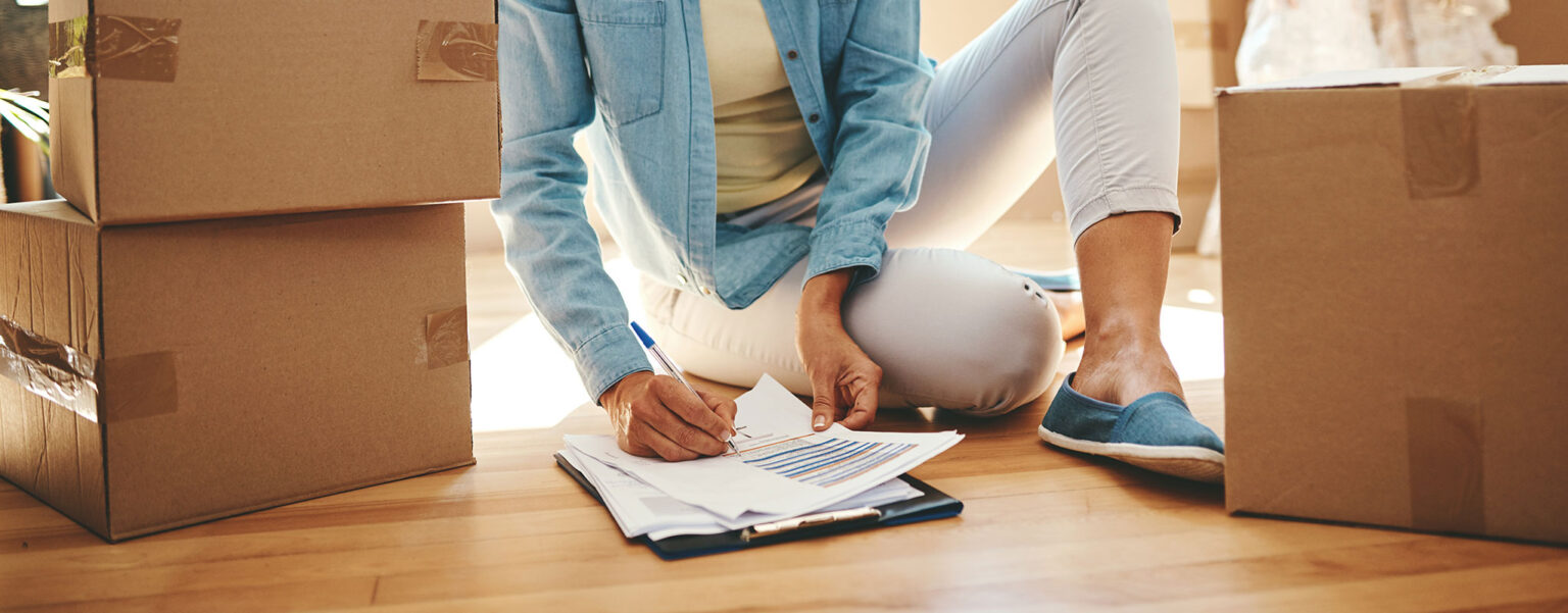 person sitting on the ground filling out a landlord reference letter