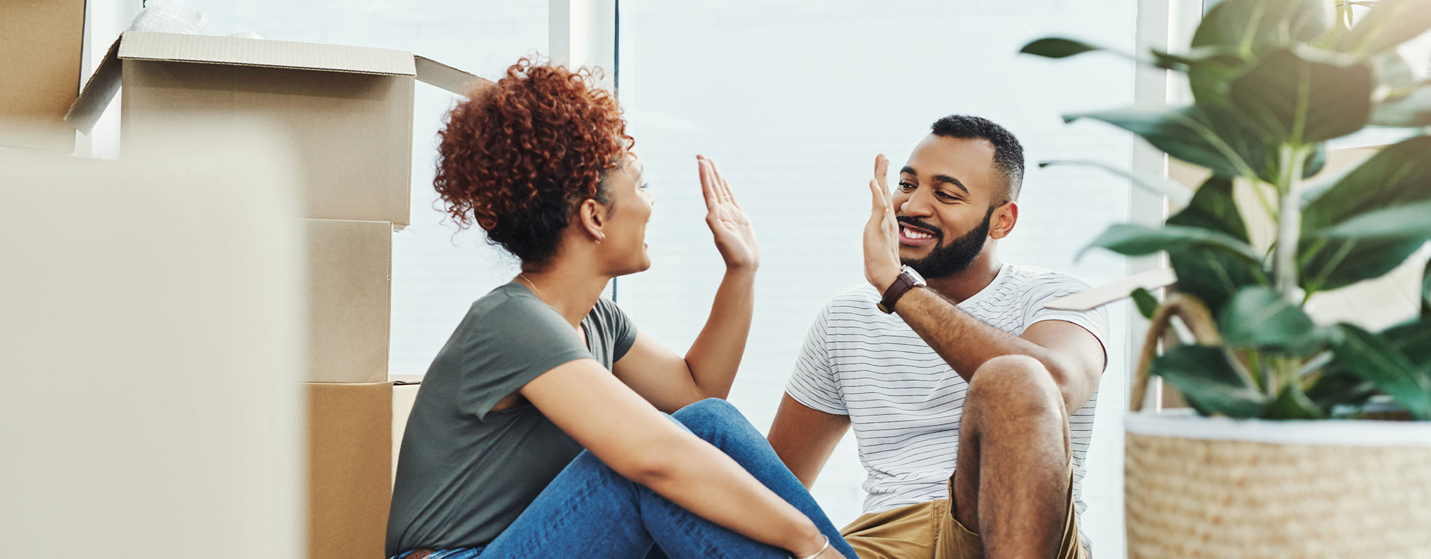 couple high fiving each other next to boxes
