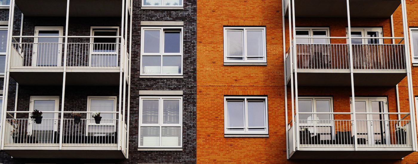 Two apartment buildings stand next to each other, sharing a wall.