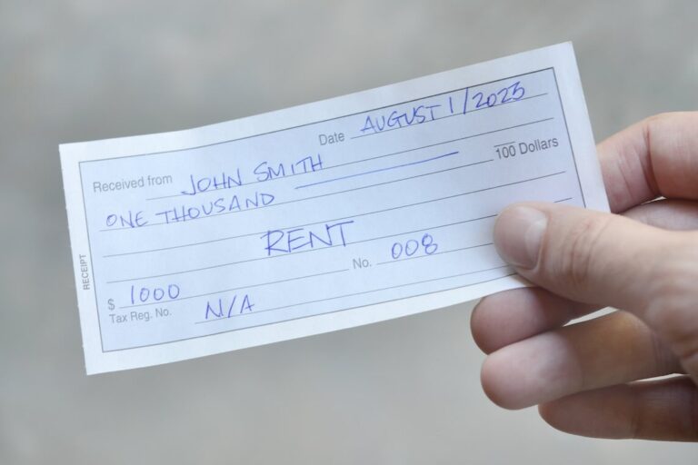landlord holding a paper receipt pulled from a rent receipt book