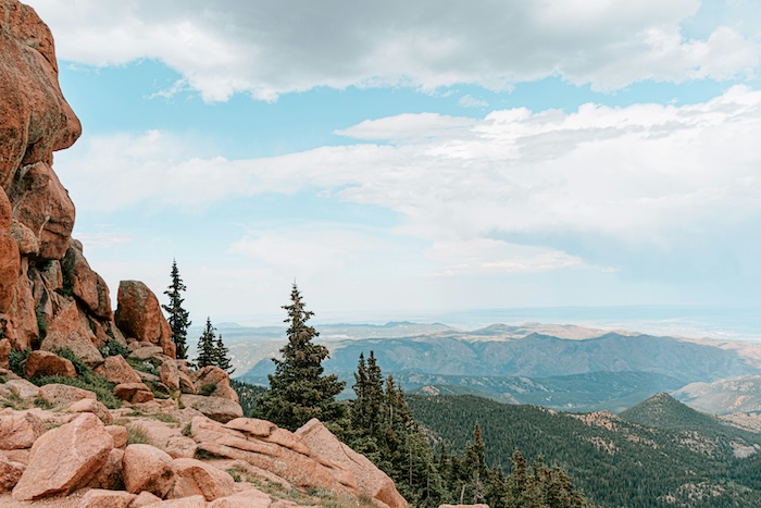 Rocky ridge in Colorado with a cloudy sky and mountains in the distance