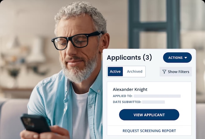 Man looking at his phone at a tenant rental application for his apartment