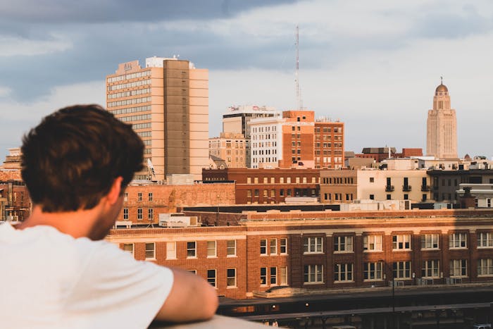 Boy in White Crew-neck T-shirt Looking on Building in Lincoln, Nebraska, US.
